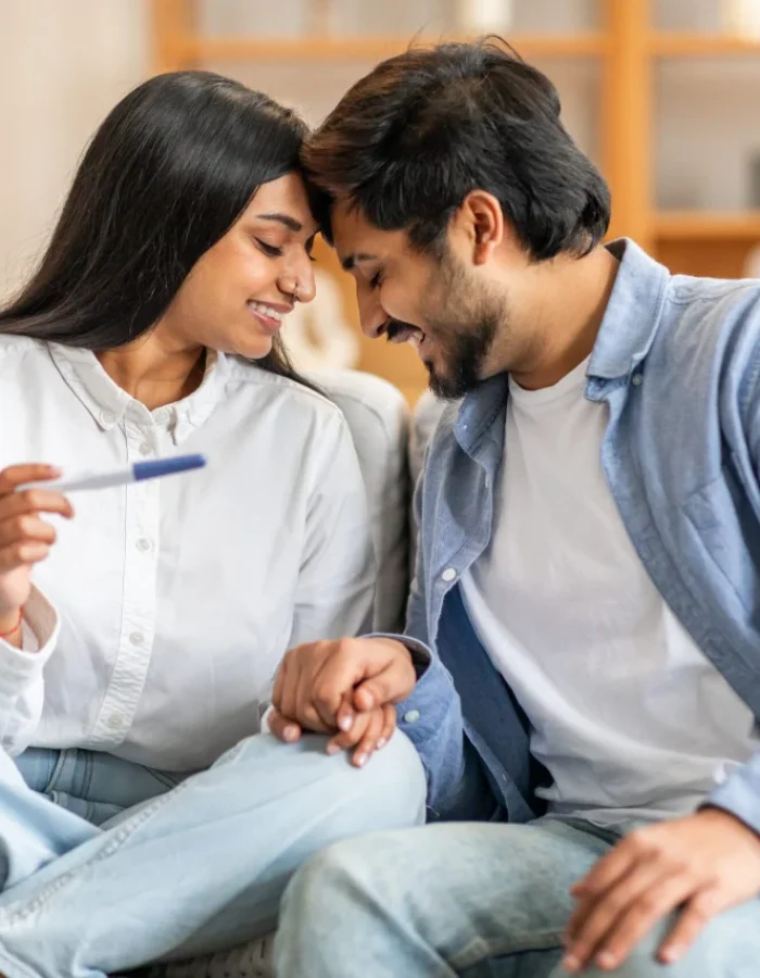 beaming-indian-couple-sits-closely-comfortable